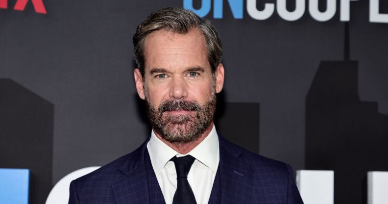 Tuc Watkins in a blue suit white shirt black tie.