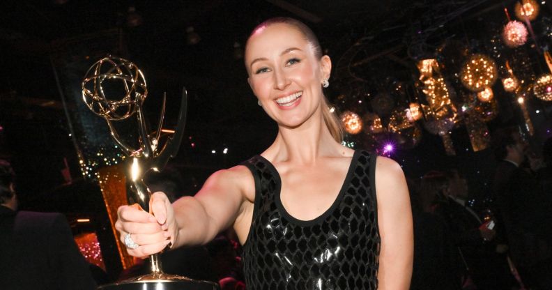 Erin Doherty smiles as she holds out her Emmy Award.