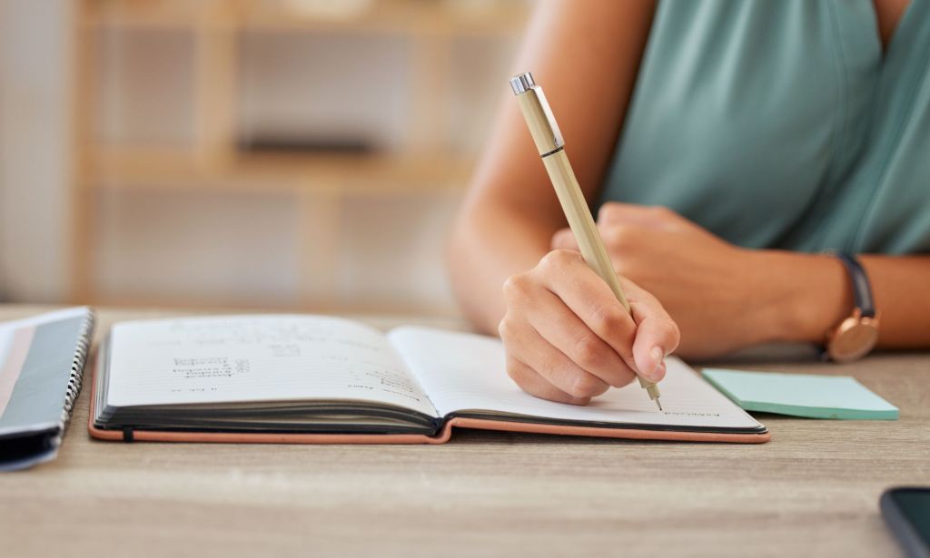 Someone writing in a book.