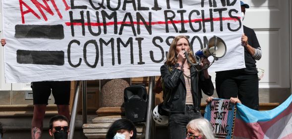 Protestors holding a sign during a trans rights rally.