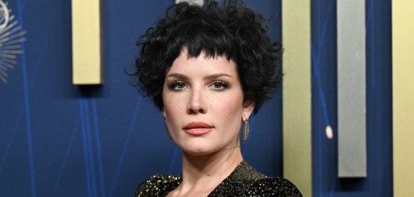 Halsey at the 77th Primetime Emmy Awards. She's wearing a snake skin patterned gold and black dress.