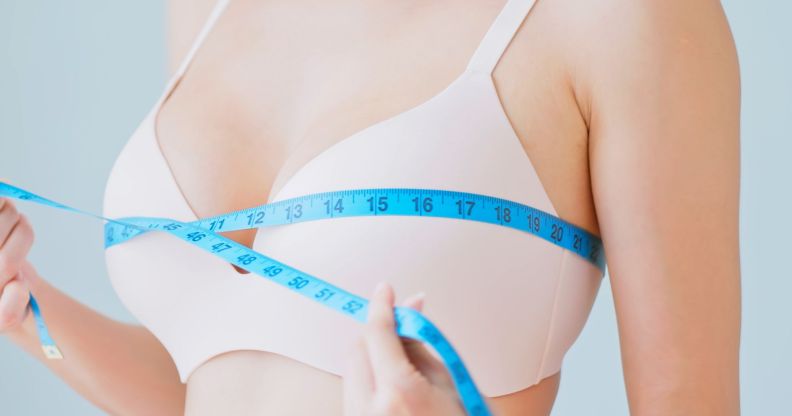 A woman wrapping a tape measure around her chest.