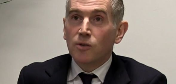 Tim Allan, pictured speaking in a suit and tie.