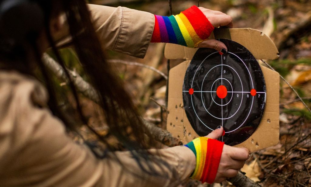 A person with rainbow gloves positioning a target.