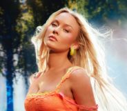Zara Larsson poses in a neon orange top for her Midnight Sun album.