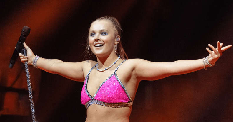 JoJo Siwa on stage in London in a pink sparkly top.