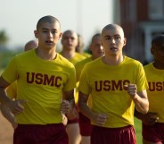 Boots still, several boys with shaved heads, all wearing yellow shirts and red shorts, running.