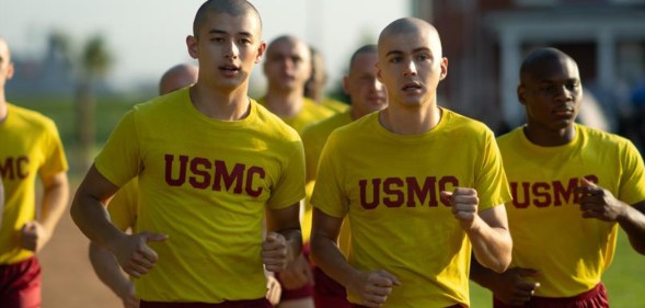 Boots still, several boys with shaved heads, all wearing yellow shirts and red shorts, running.