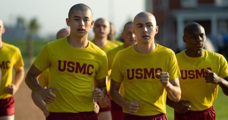 Boots still, several boys with shaved heads, all wearing yellow shirts and red shorts, running.
