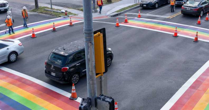Workers are seen while cars pass along Westheimer.