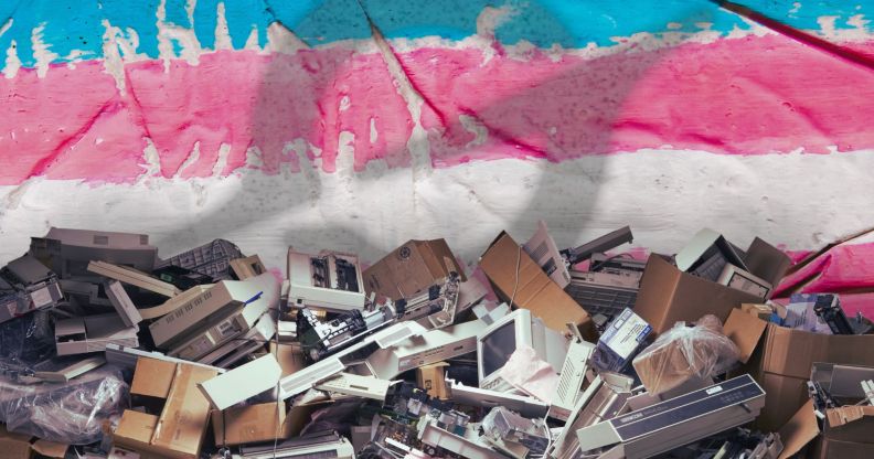 A pile of broken tech edited in front of a trans flag with the Grok logo superimposed over it.