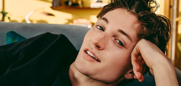 Henry Moodie poses with his head resting on his hand.