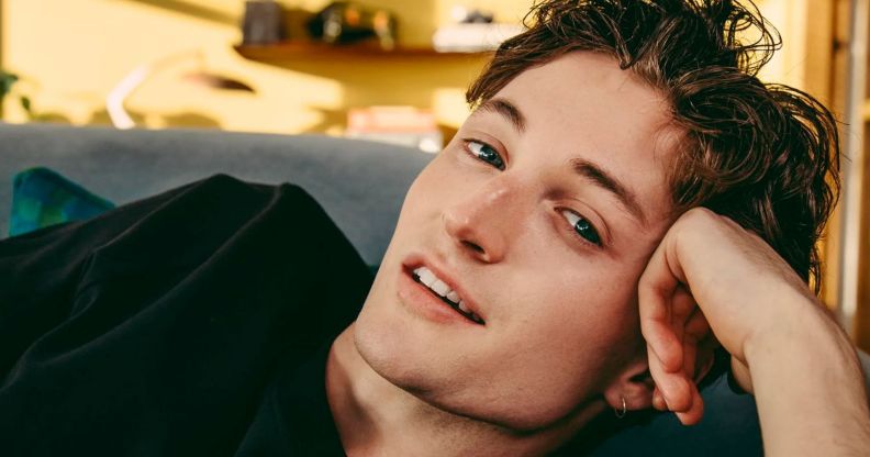 Henry Moodie poses with his head resting on his hand.