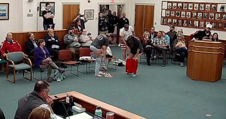 Three activists stood up and began to strip as Nick Blanchard continued to speak.