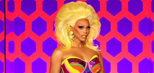 RuPaul smiling on the Drag Race judging panel.