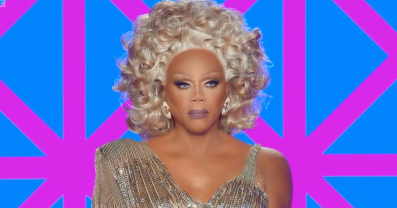 RuPaul in a gold shiny dress on the judging panel of Drag Race UK season 7.