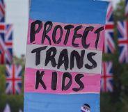 A sign reading "protect trans kids" surrounded by banners of the Union Jack.