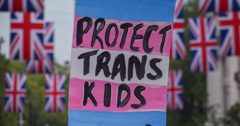 A sign reading "protect trans kids" surrounded by banners of the Union Jack.