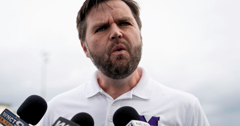 JD Vance, pictured speaking into a set of microphones.