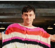 Tom Daley is the host of Game of Wool: Britain’s Best Knitter. Standing with a brightly knitted poncho