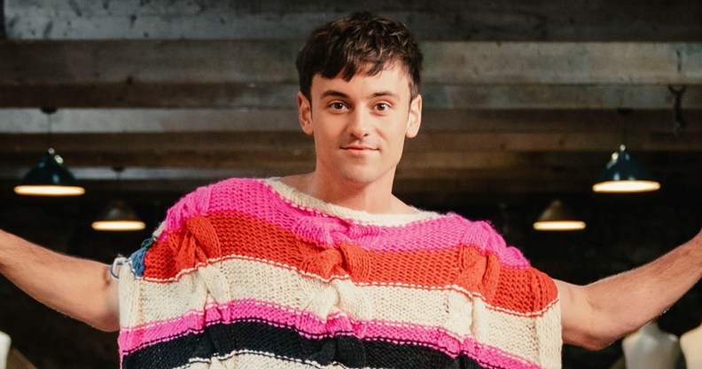 Tom Daley is the host of Game of Wool: Britain’s Best Knitter. Standing with a brightly knitted poncho