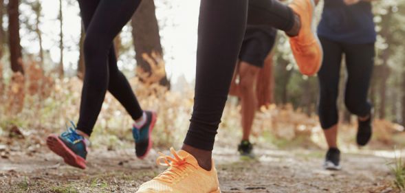 A photo of the lower torsos of a group of runners.