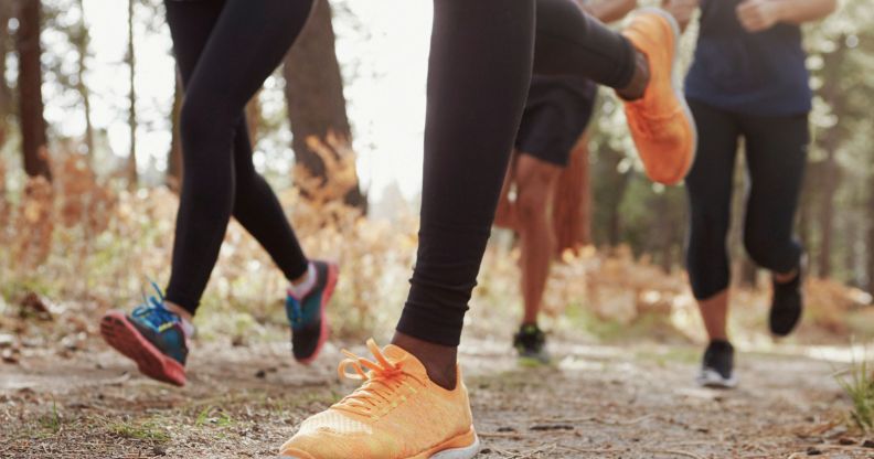 A photo of the lower torsos of a group of runners.