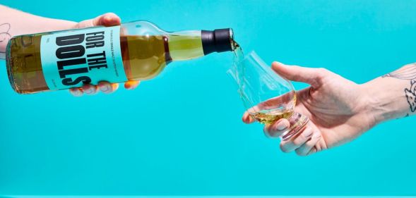 An unpictured person pouring a bottle of the For the Dolls whisky.