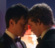 Heated Rivalry still: Shane (Tracker actor Hudson Williams) and Ilya (Joker: Folie à Deux star Connor Storie) resting their heads together, both wearing suits