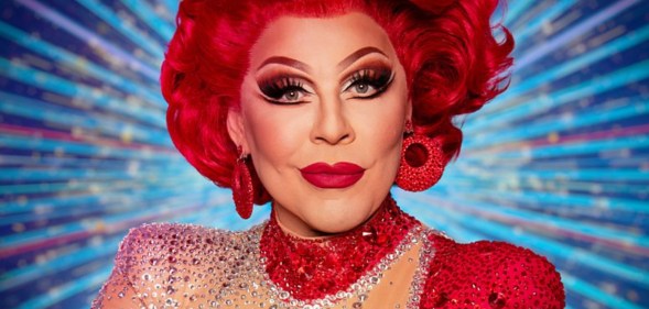 La Voix in all red in front of a blue strictly background