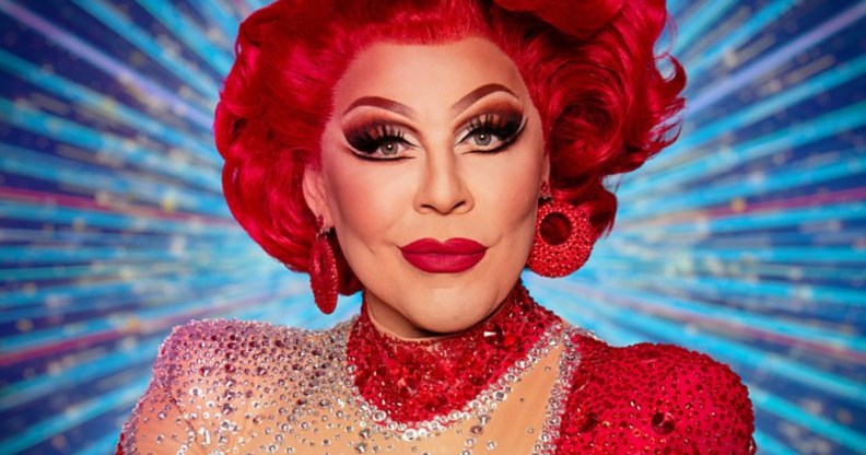 La Voix in all red in front of a blue strictly background