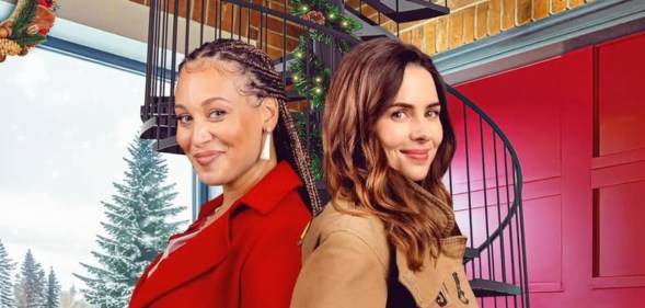 Two women stood back to back in a christmas decorated firefighter station