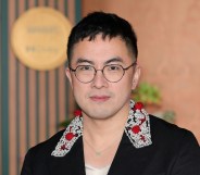 Bowen Yang in a black suit with an embroided collar, white and red detailing
