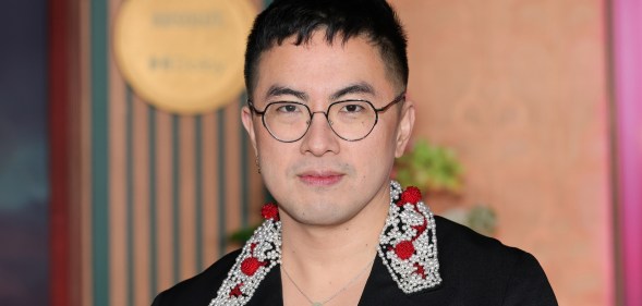 Bowen Yang in a black suit with an embroided collar, white and red detailing