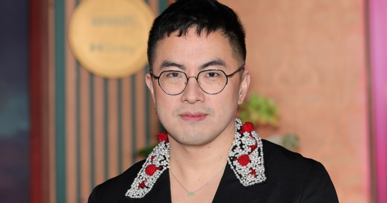 Bowen Yang in a black suit with an embroided collar, white and red detailing