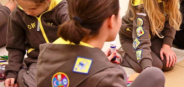 A group of Girlguiding Brownies sat doing arts and crafts.