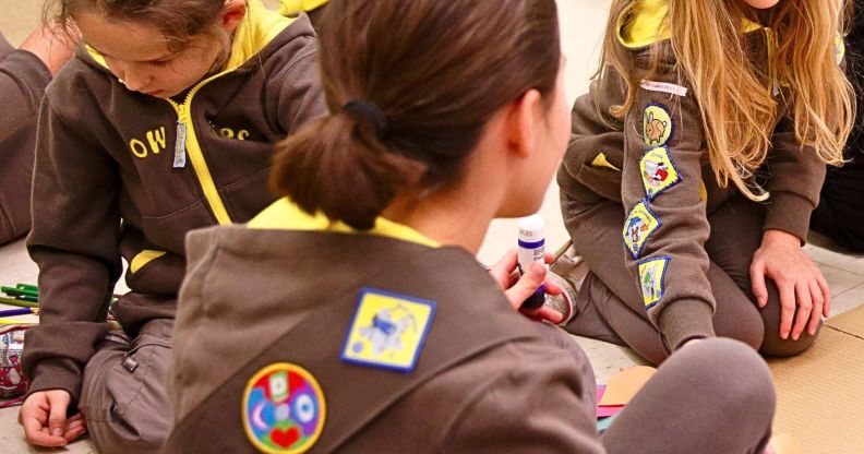 A group of Girlguiding Brownies sat doing arts and crafts.
