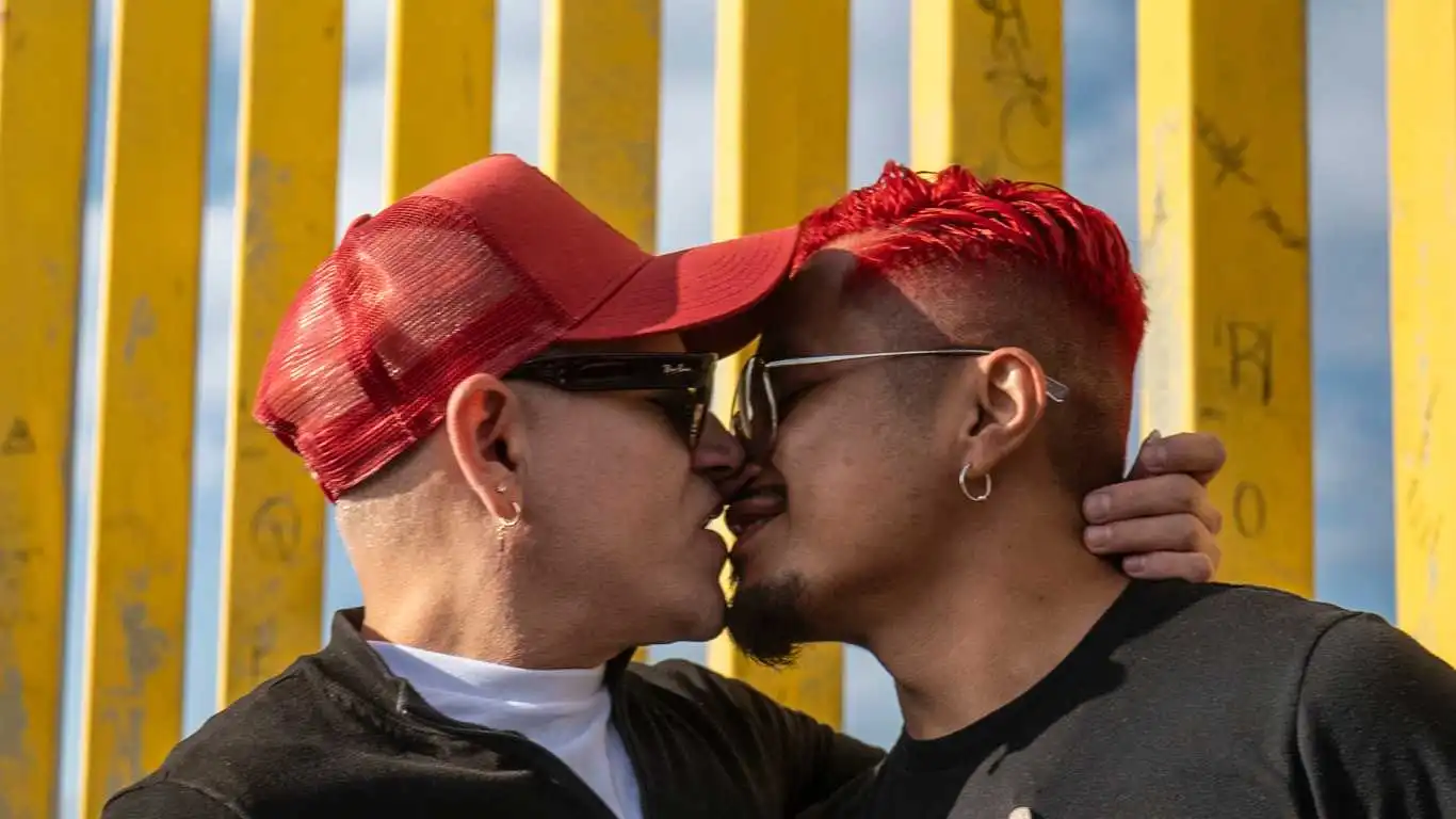HIV-positive men hold kiss-in next to Trump's border wall for World AIDS Day
