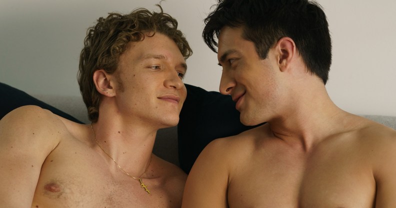 Ilya Rozanov (Connor Storrie) and Shane Hollander (Hudson Williams) shirtless in bed together.
