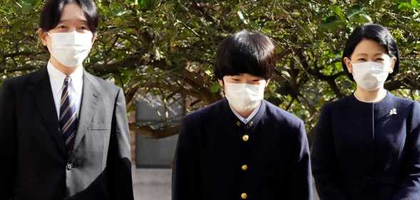 Japan's Prince Hisahito (C), accompanied by his parents Crown Prince Akishino and Crown Princess Kiko, pose for media before his graduation ceremony of a junior high school affiliated with Ochanomizu University in Tokyo