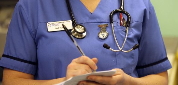 A nurse writing on a document.