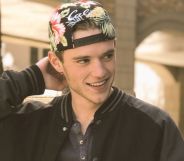 A photo of Rhett Douglas Messerly smilingin a black jacket and multicoloured cap.
