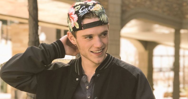 A photo of Rhett Douglas Messerly smilingin a black jacket and multicoloured cap.
