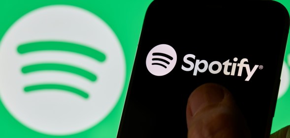 Close-up images show the Spotify logo and mobile application interface on a smartphone screen.
