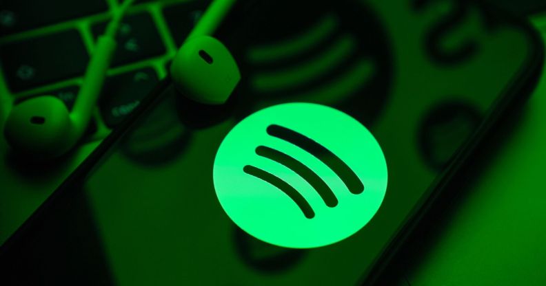 A phone in a green light with the Spotify symbol.