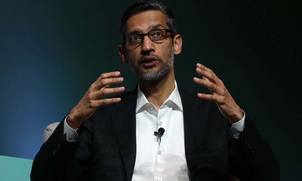 Sundar Pichai in a suit and tie speaking at a conference. 