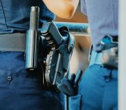 The waist of a police officer, which has a gun attached.