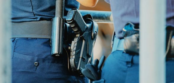 The waist of a police officer, which has a gun attached.