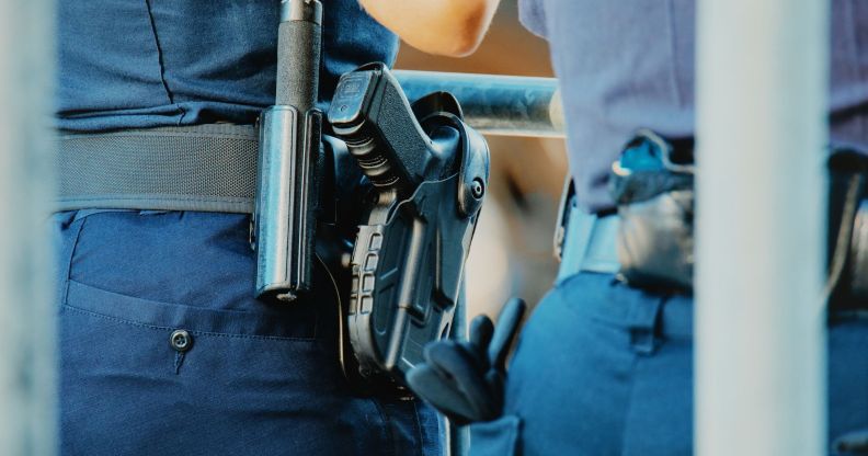 The waist of a police officer, which has a gun attached.