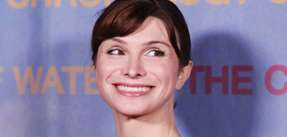 Dylan Mulvaney smiling on a light blue background